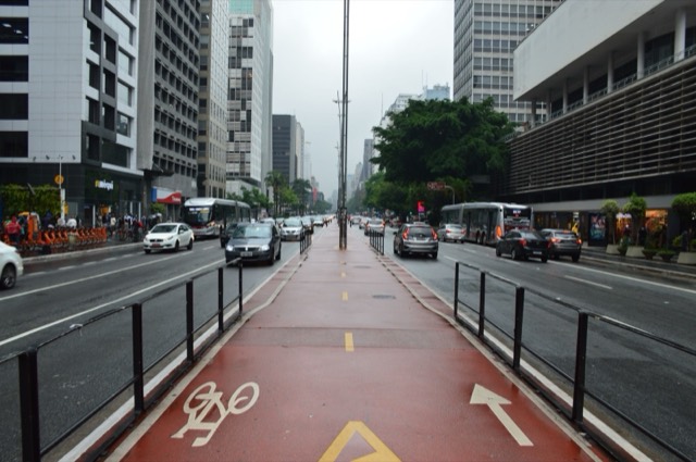 A view of Avenida Paulista in São Paulo with bike path and traffic on a cloudy day.